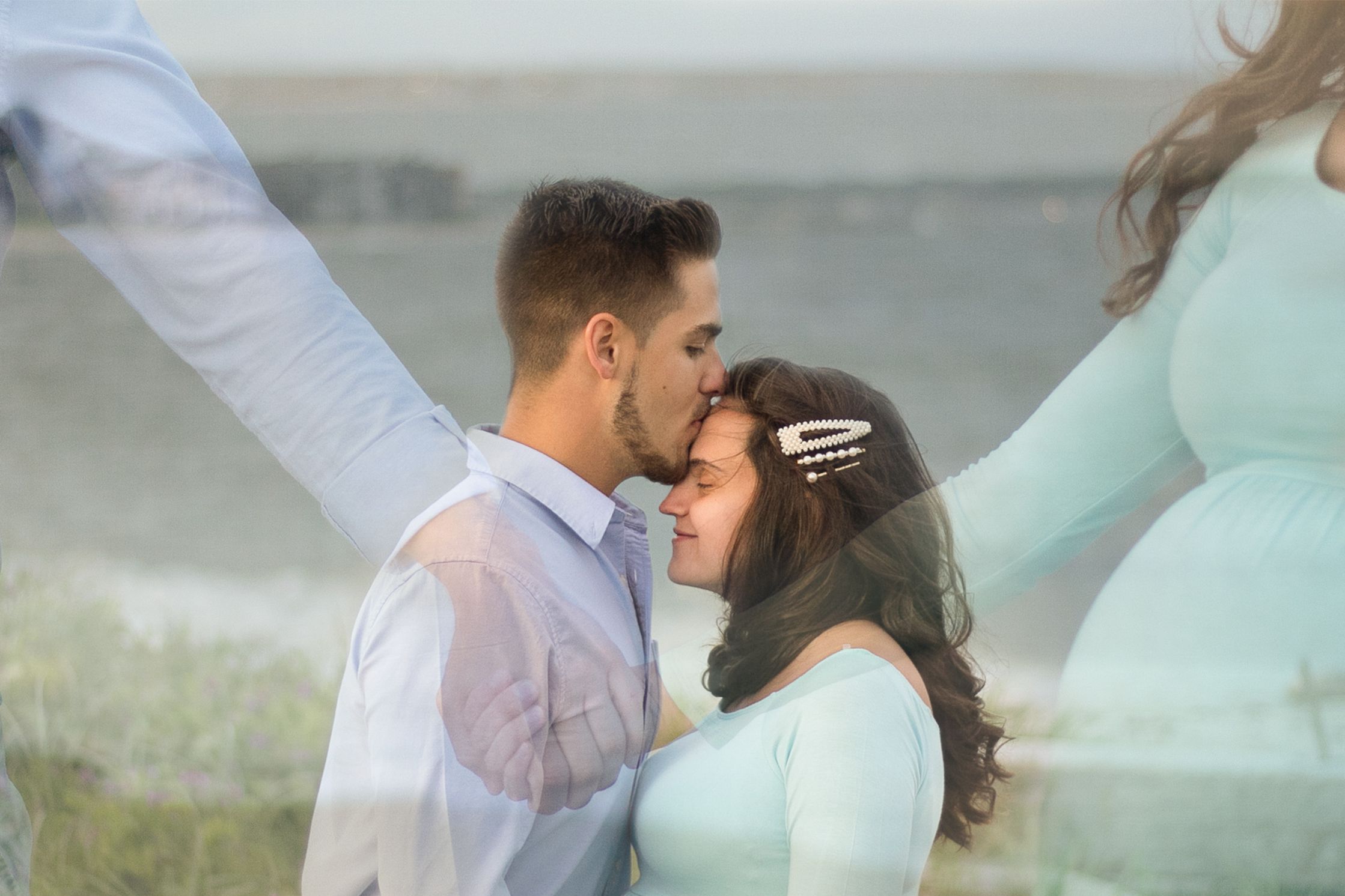 Double exposure of beautiful couple holding hands and forehead kiss at the beach during maternity shoot