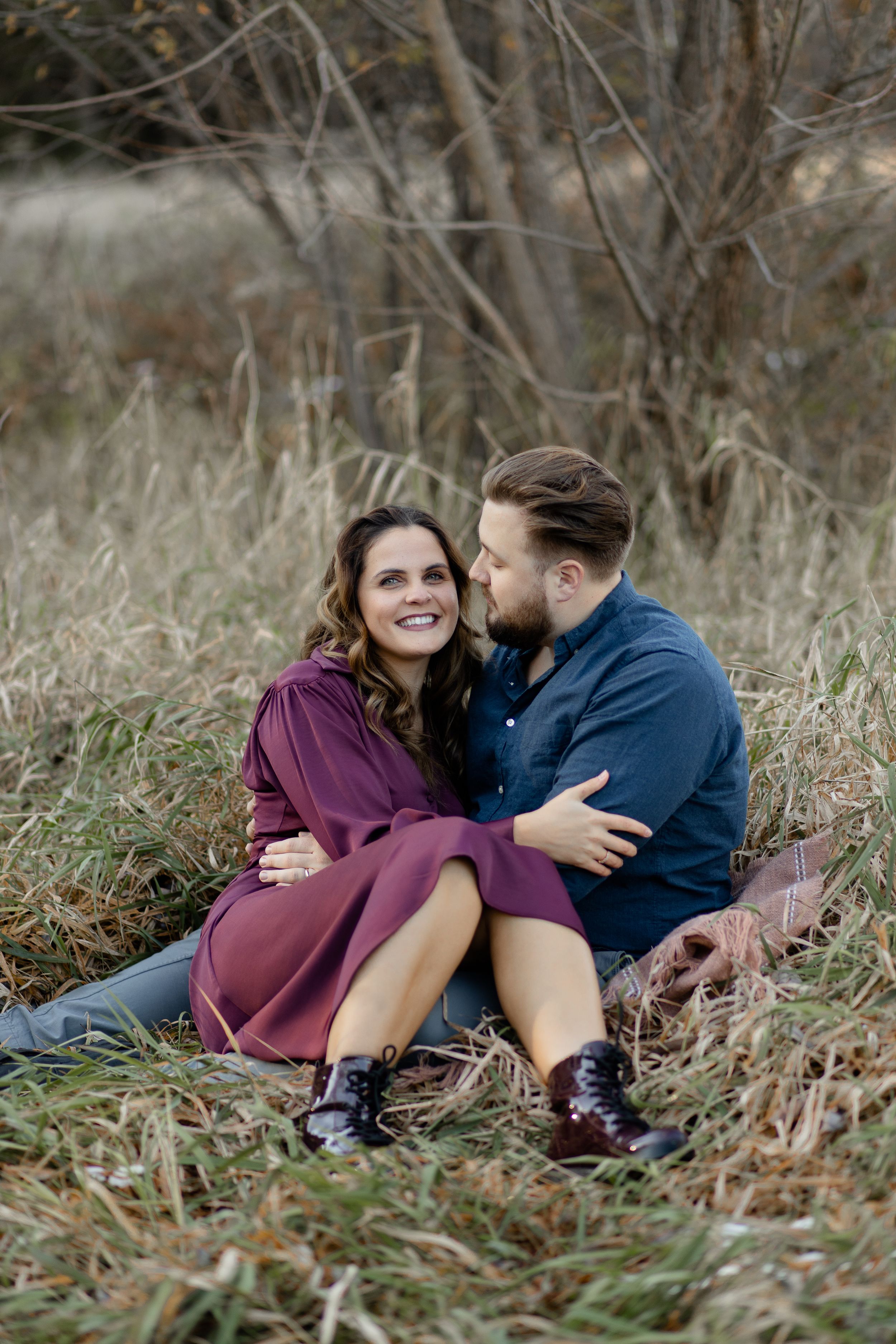 Couple snuggling in a field during Christmas photoshoot