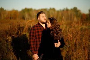 Beautiful couple posing in field during golden hour