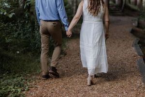 Couple holding hands walking in the woods