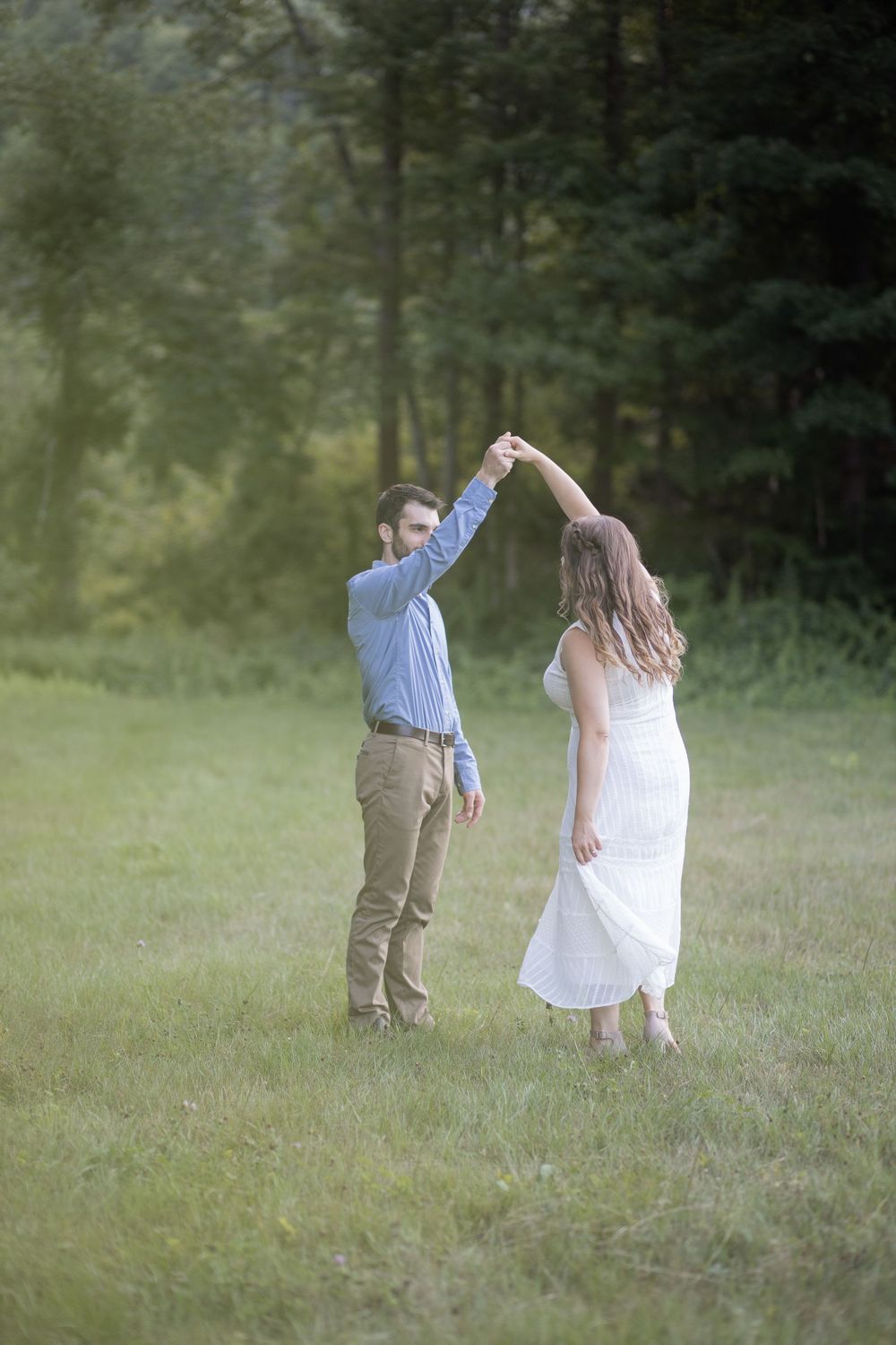 Beautiful engaged couple dancing in a field