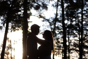 Silhouettes of couple looking at each other in the woods