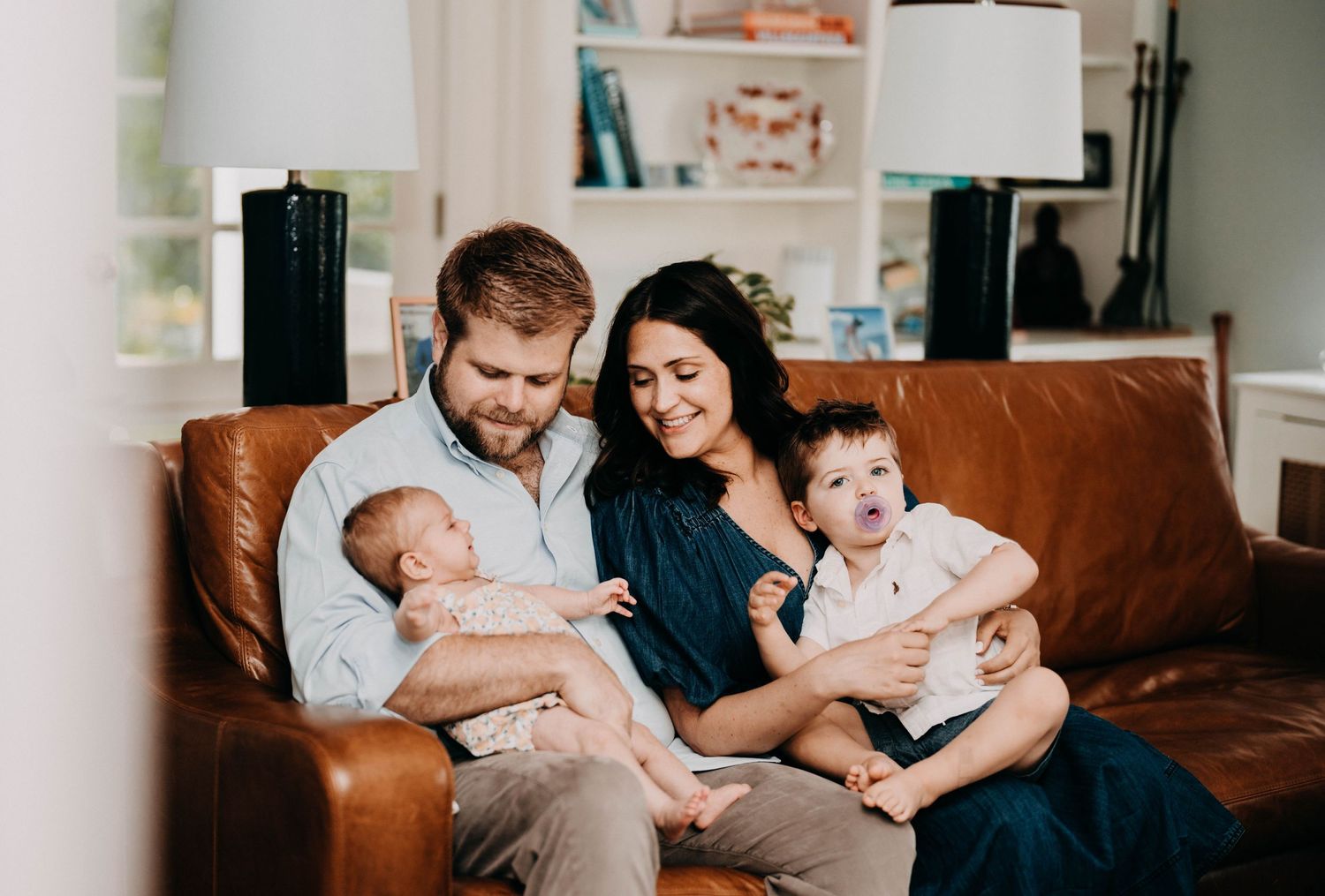 Happy family moment captured on leather sofa in cozy living room setting.