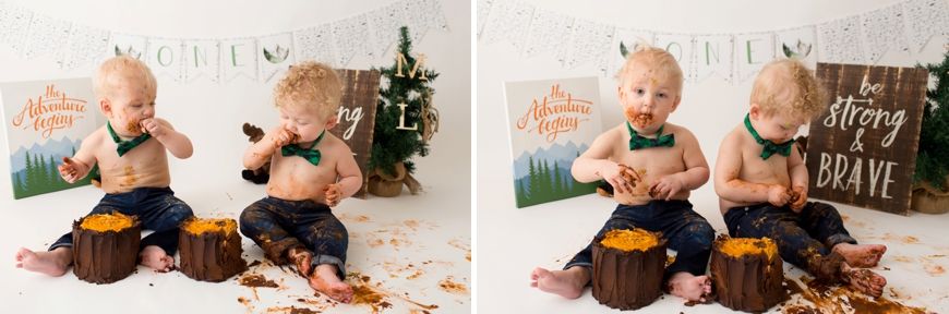 Two children enjoying messy cake smash with orange frosting and woodland decorations.