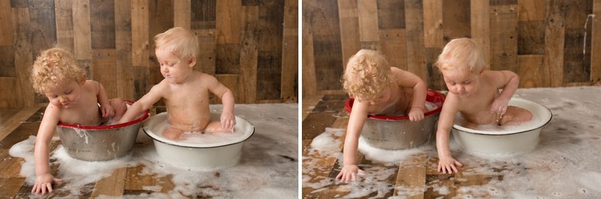 Two babies sitting in metal wash tubs during rustic themed photoshoot.