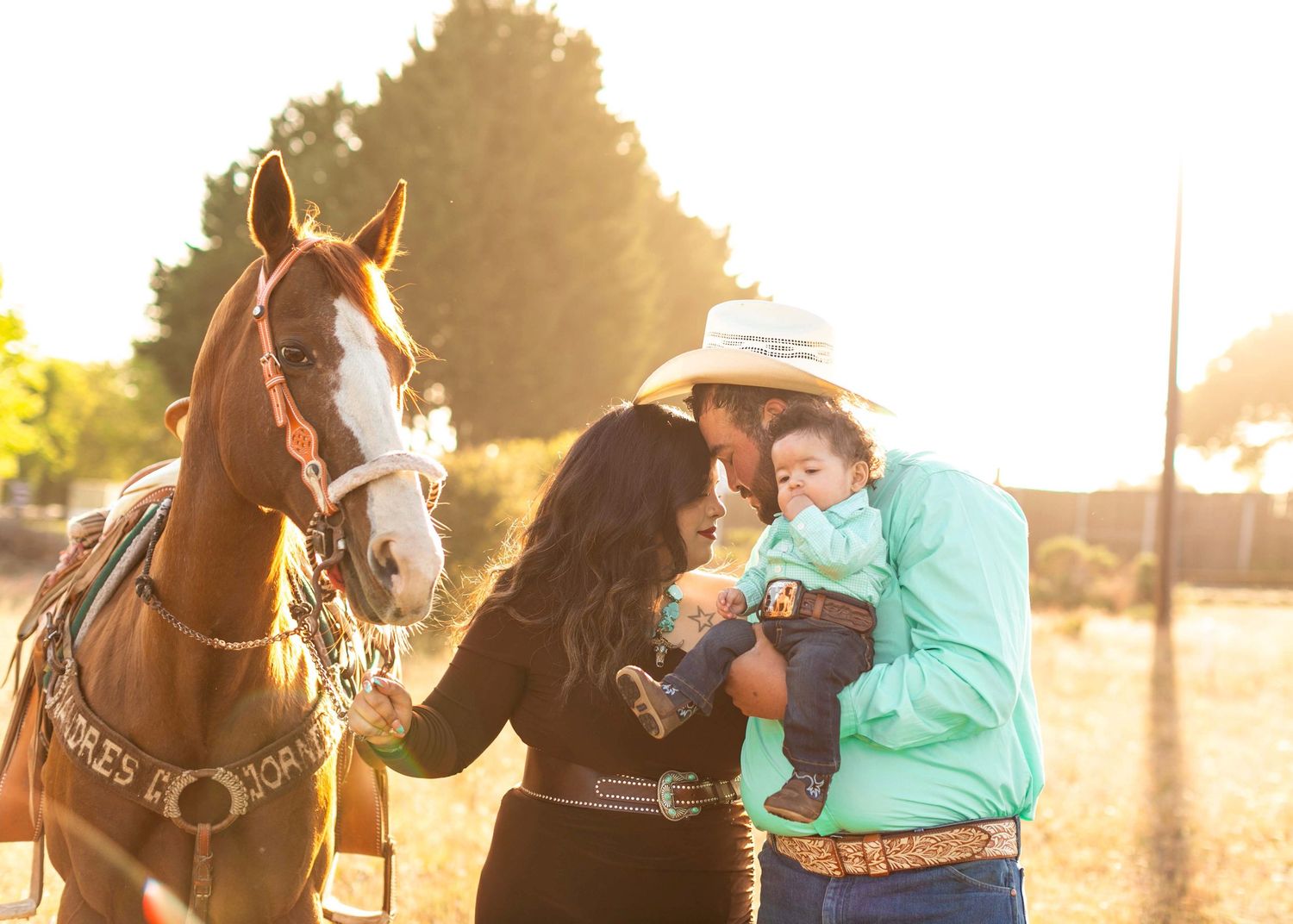 Family posing with their horse during golden hour outdoor photo session.