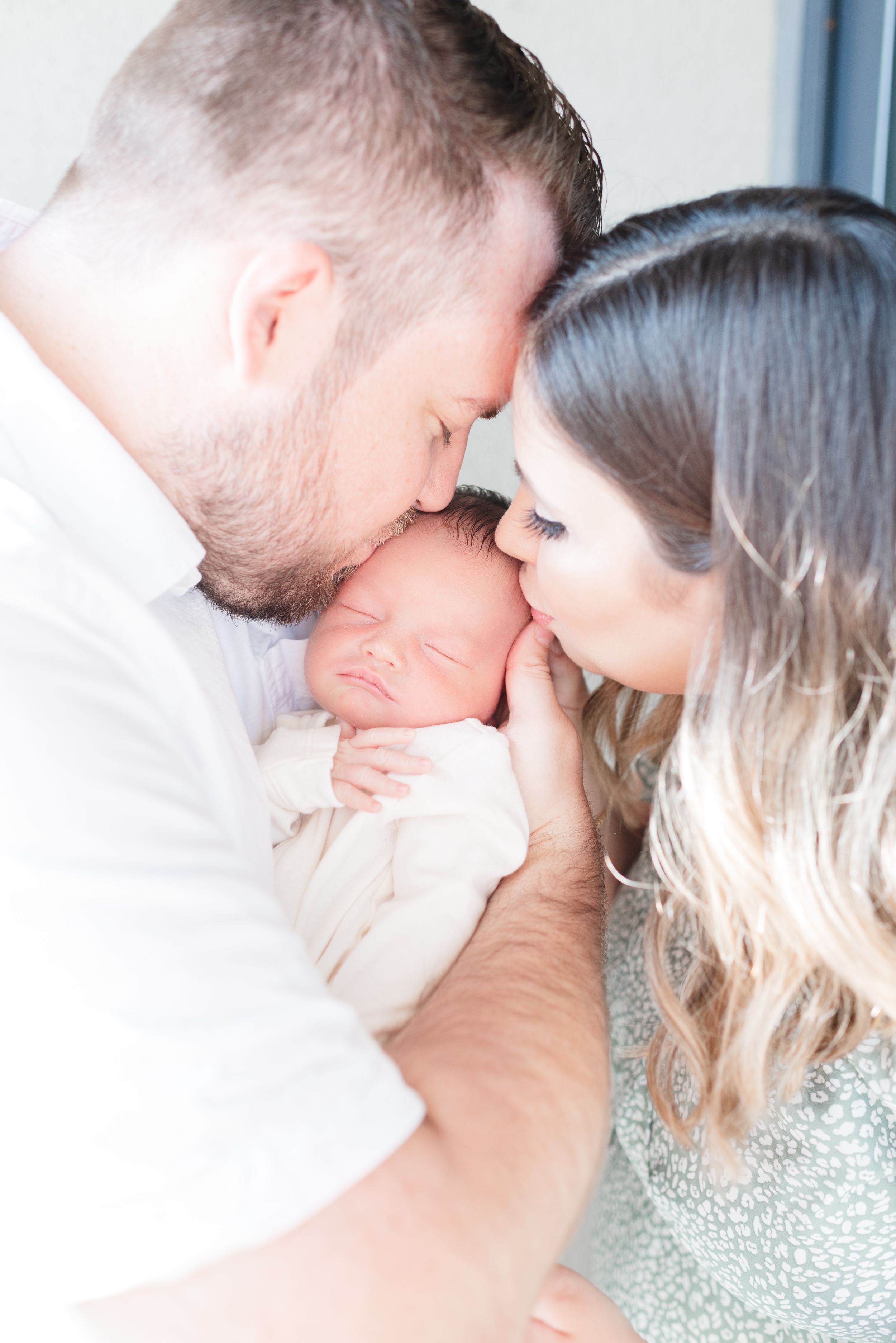 Parents kissing newborn at an in home newborn photoshoot captured by Toronto Newborn Photographer Jess GC Photography