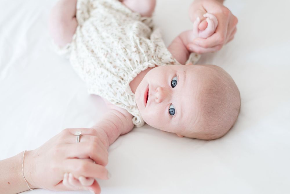 Baby holding parents hands at an in home newborn shoot captured by Toronto Newborn Photographer Jess GC Photography