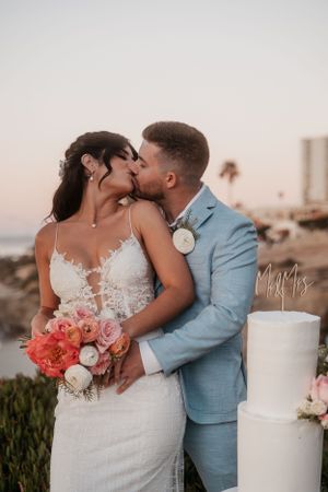 Intimate sunset beach wedding photo session with romantic floral details.