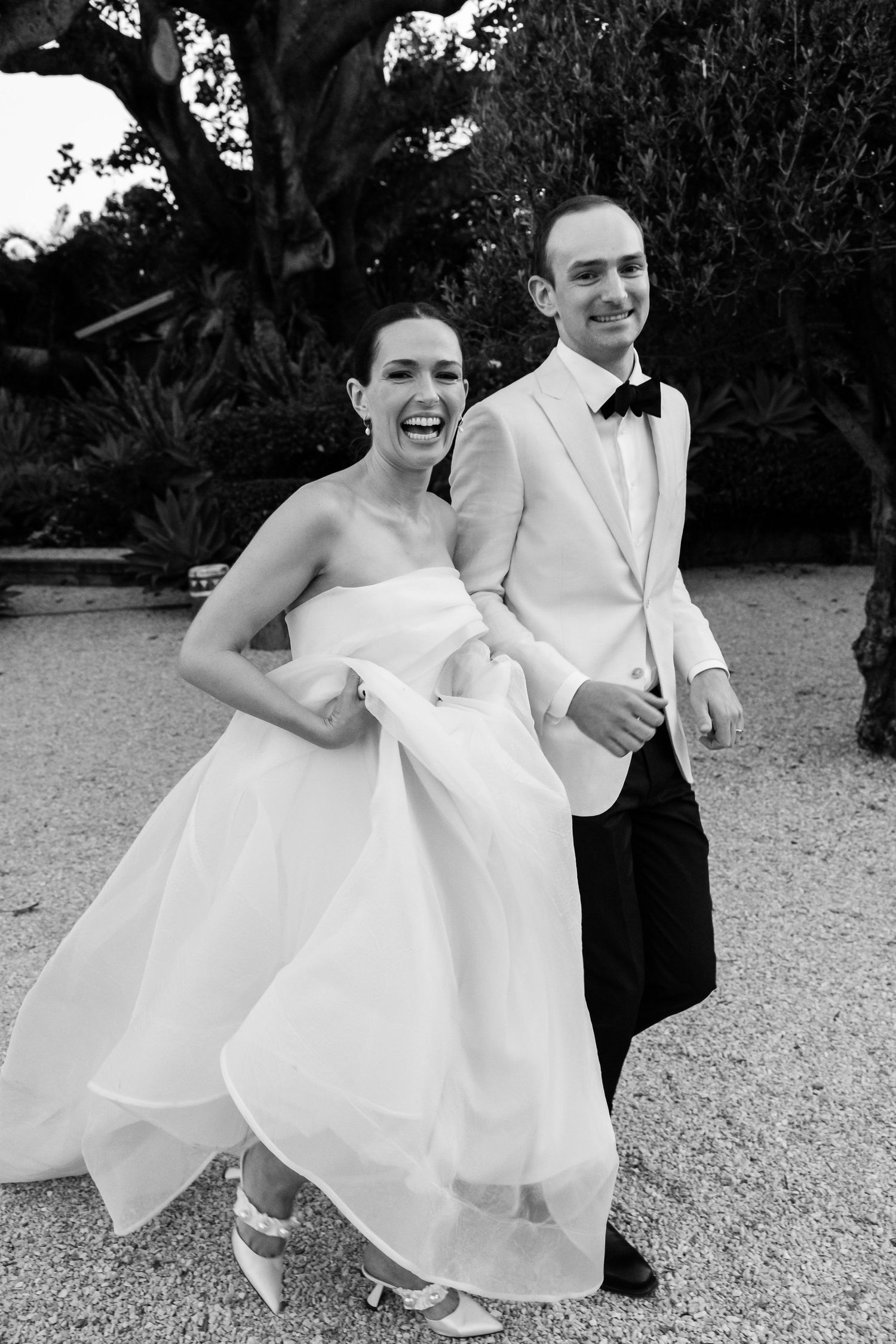 A joyful wedding couple shares a candid moment in formal attire.