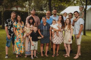 Extended family gathered outdoors for a casual group photo on a sunny day.