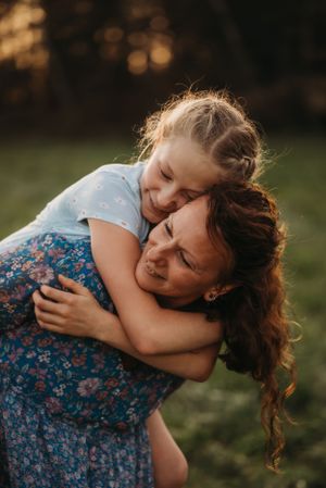 An intimate embrace captured in warm sunset lighting against a natural outdoor backdrop.