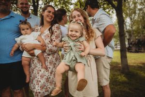 Candid family moment showing laughter and smiles during an outdoor photoshoot.