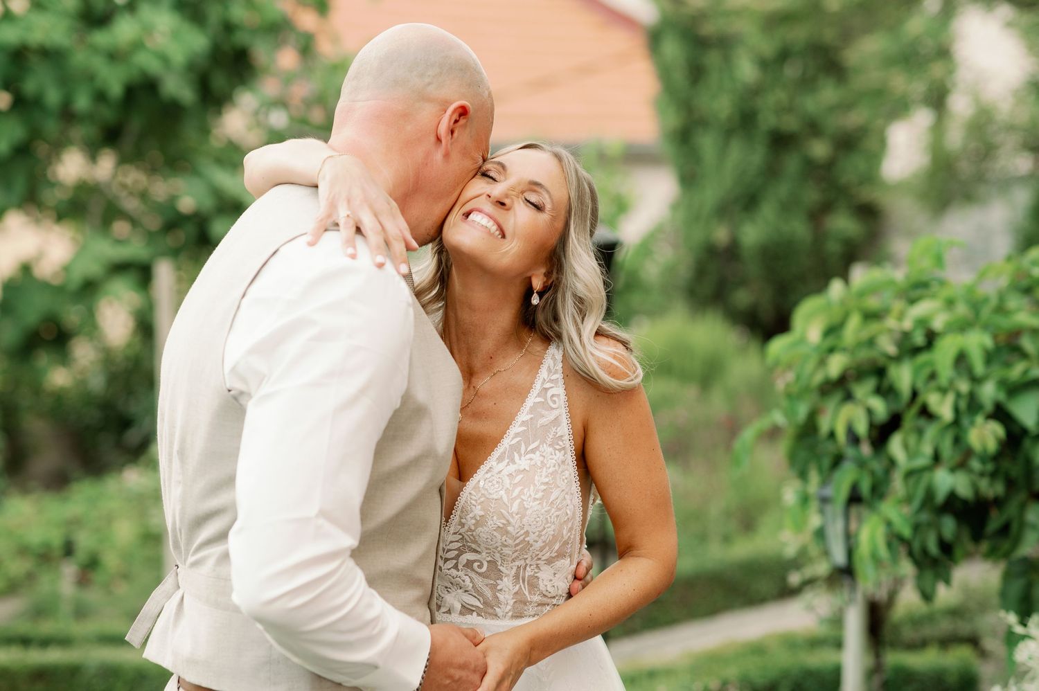 Romantic moment between newlyweds in a lush garden setting during their wedding day.