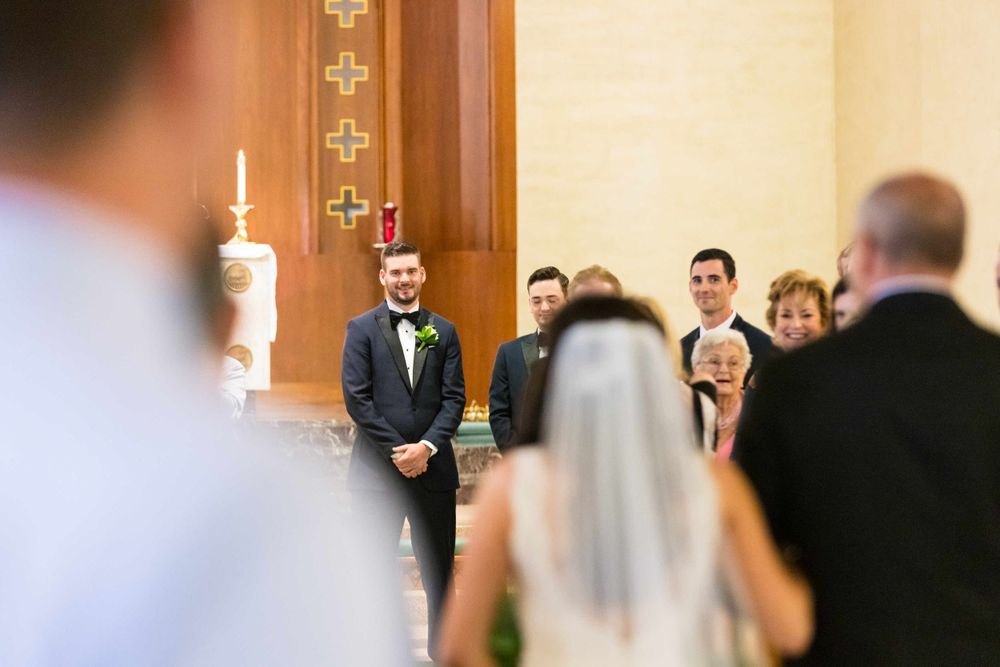 Traditional church wedding ceremony with guests seated in wooden pews.