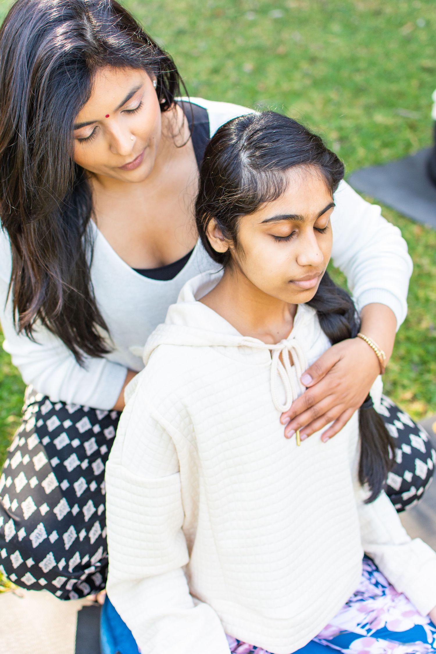 Sweet outdoor portrait of parent and child sitting together on grass.