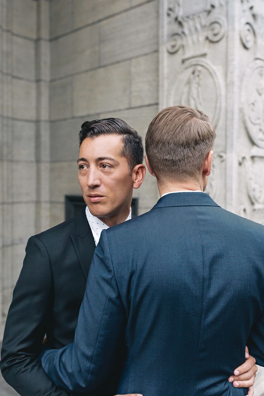 Candid profile shot of a groom looking affectionately at his partner during their outdoor wedding session.