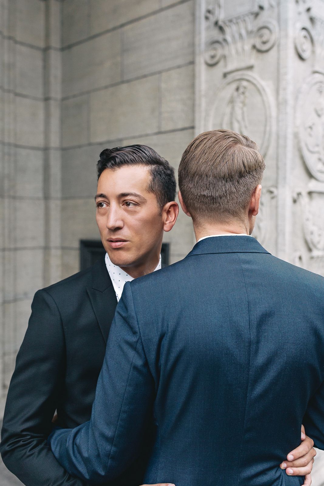 Candid profile shot of a groom looking affectionately at his partner during their outdoor wedding session.
