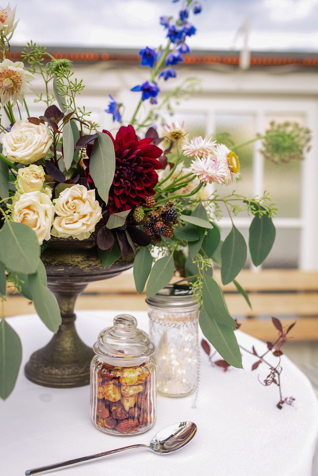 Close-up detail of a beautifully decorated wedding table featuring greenery and white flowers.