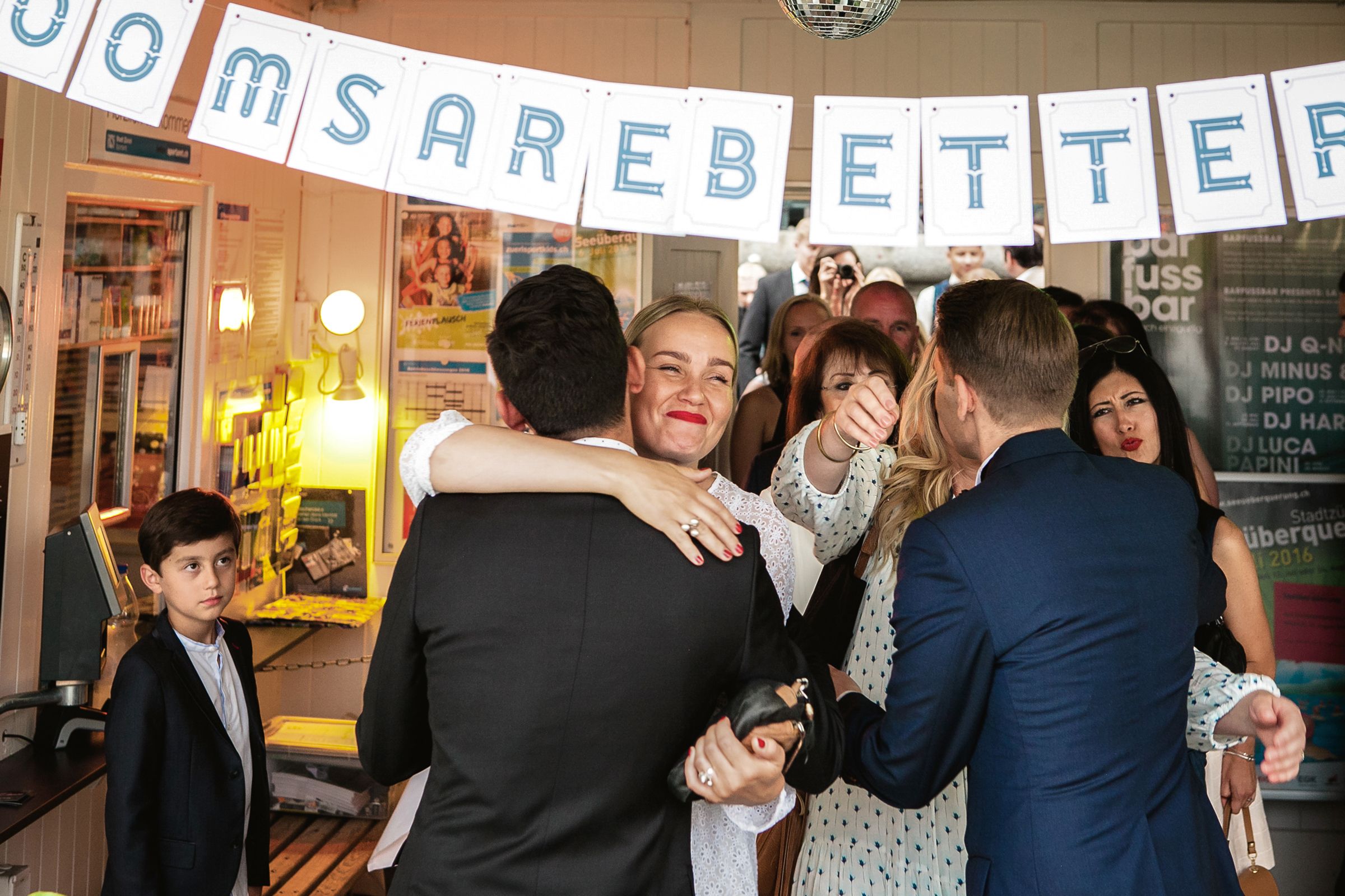 Candid indoor wedding reception shot of guests celebrating.