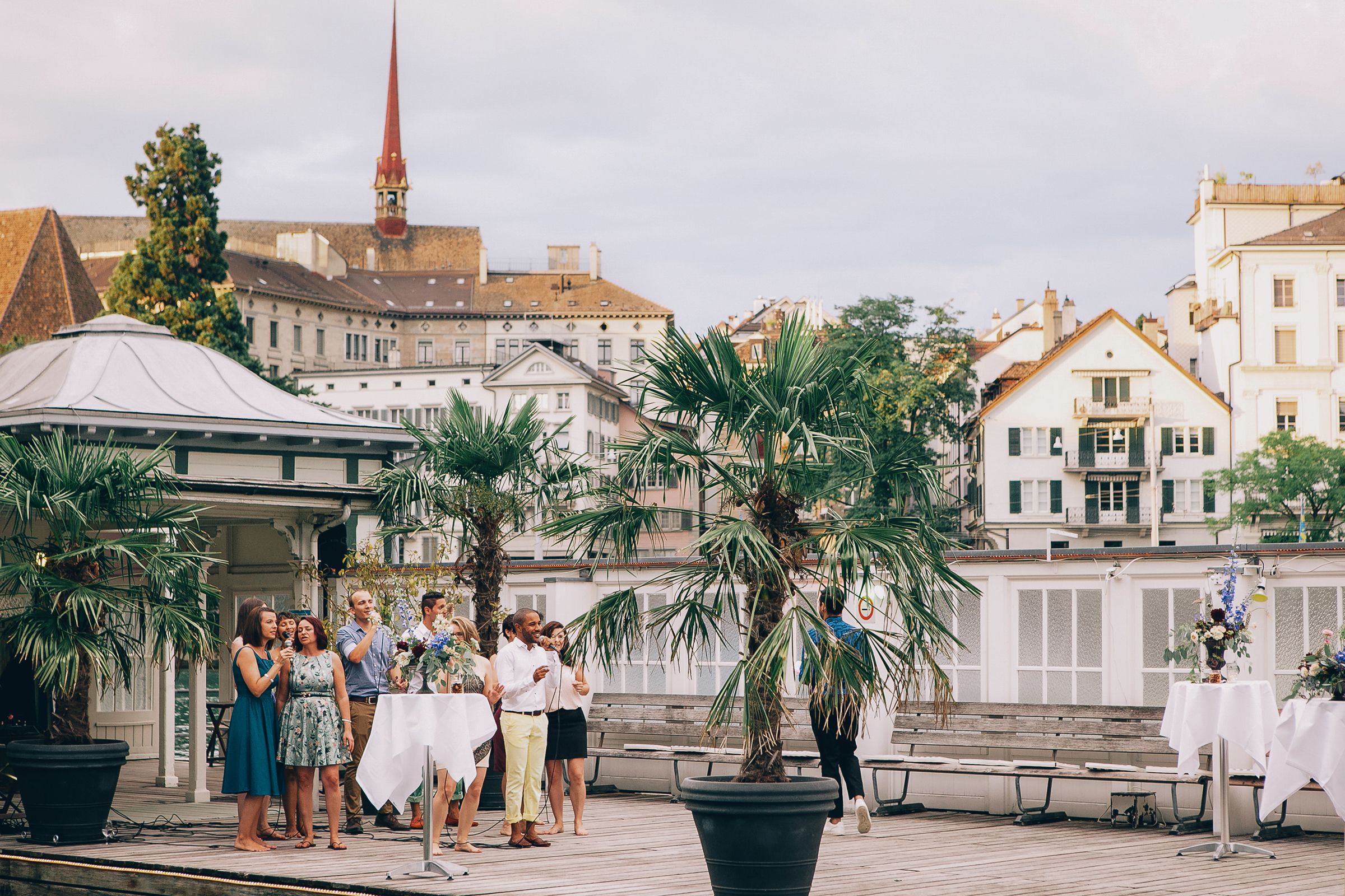 A joyful wedding party celebrating by the waterfront in Zurich, surrounded by scenic views and elegant decorations.