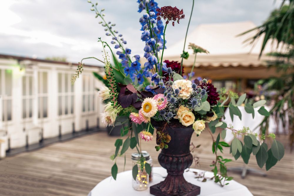 A beautifully arranged table with vibrant flowers, set against a patio.