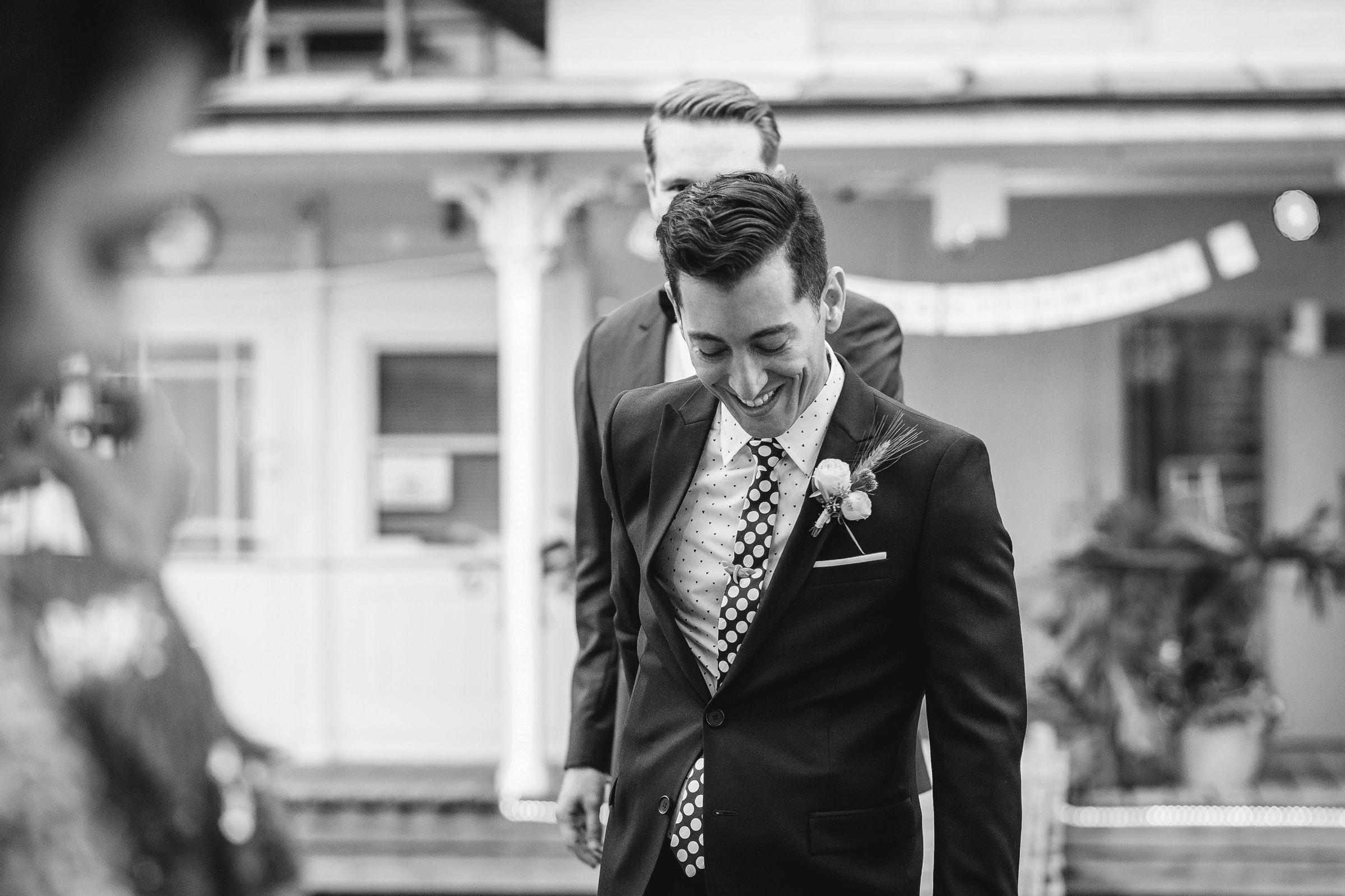 A groom in a suit walking outdoors.