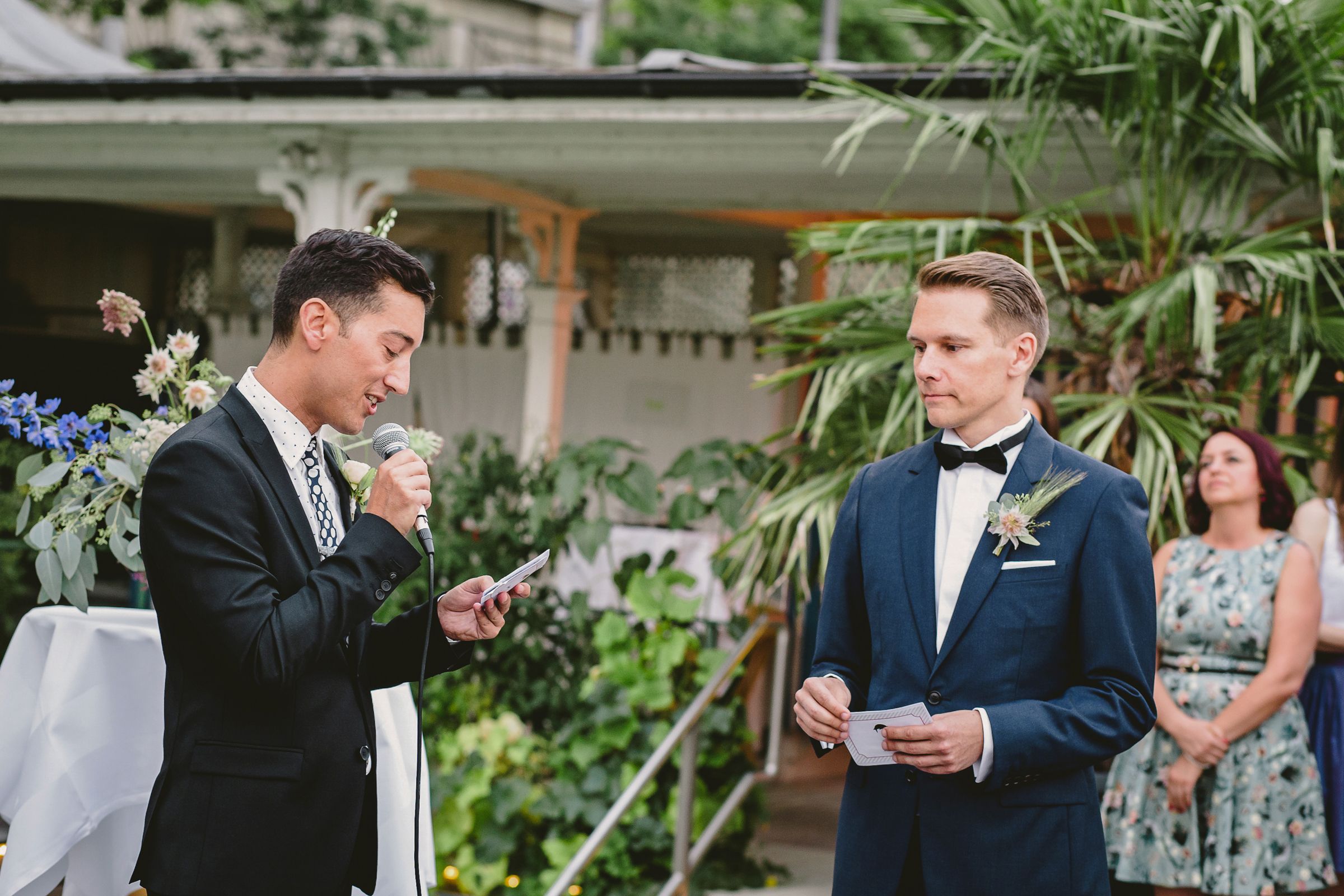 An elegant wedding ceremony in Zurich, showcasing a gay couple exchanging vows amidst a scenic backdrop and joyful attendees.