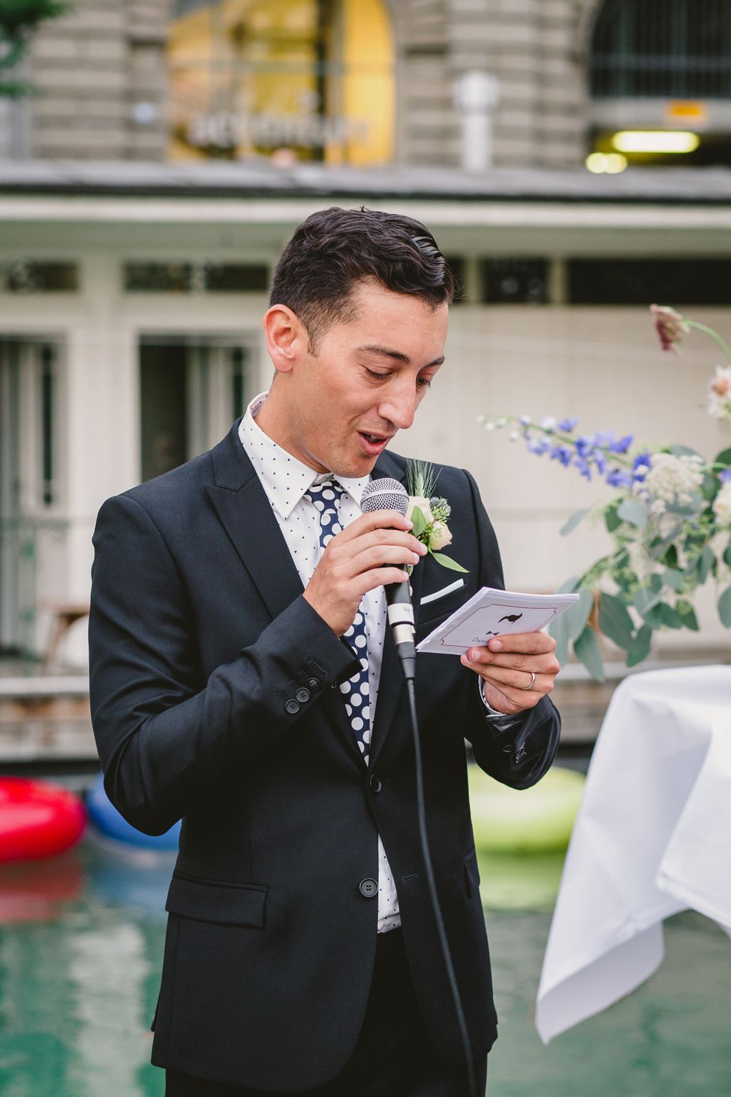 An elegant groom at a wedding ceremony in Zurich, exchanging vows amidst a scenic backdrop and joyful attendees.
