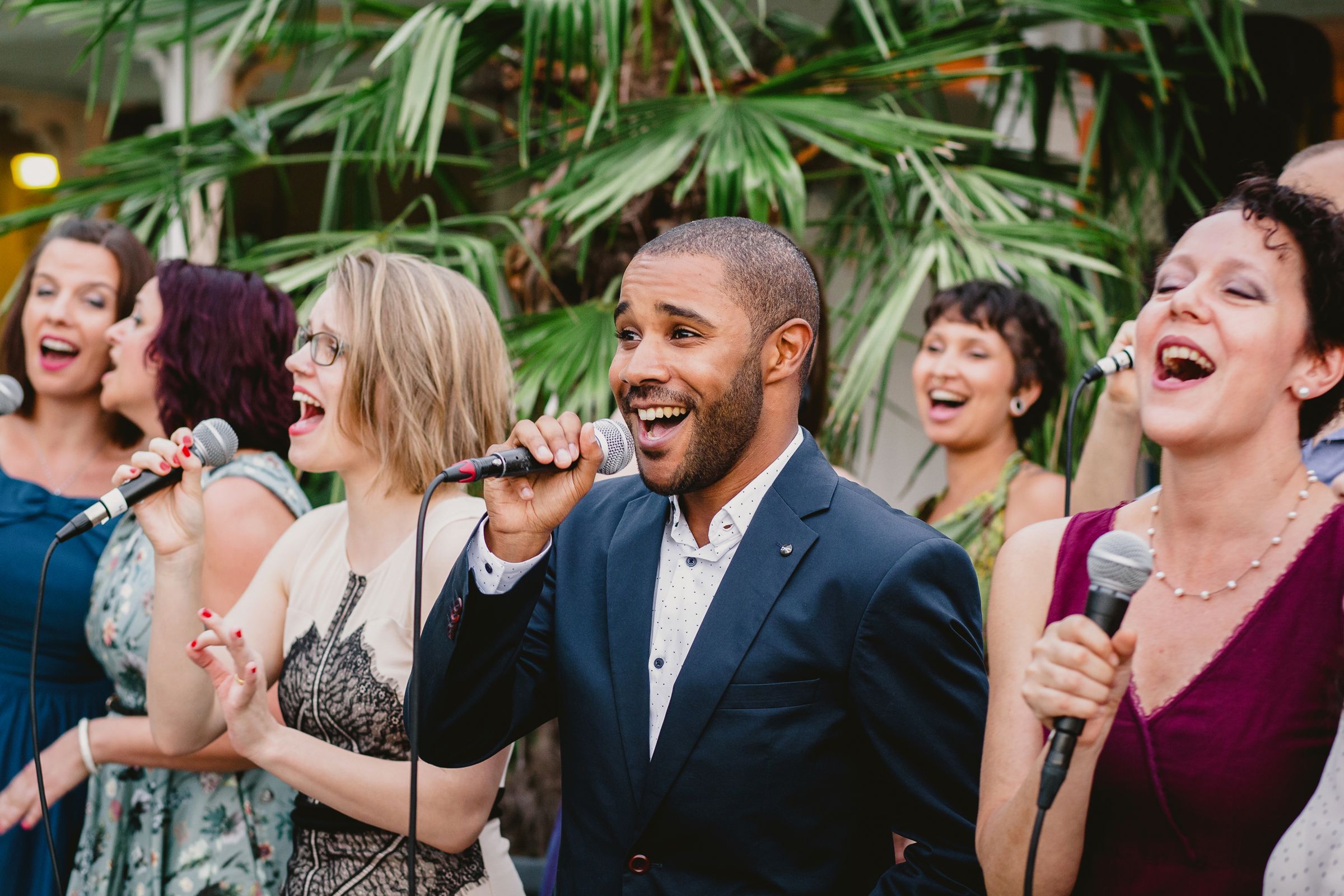 A black man singing passionately on stage.