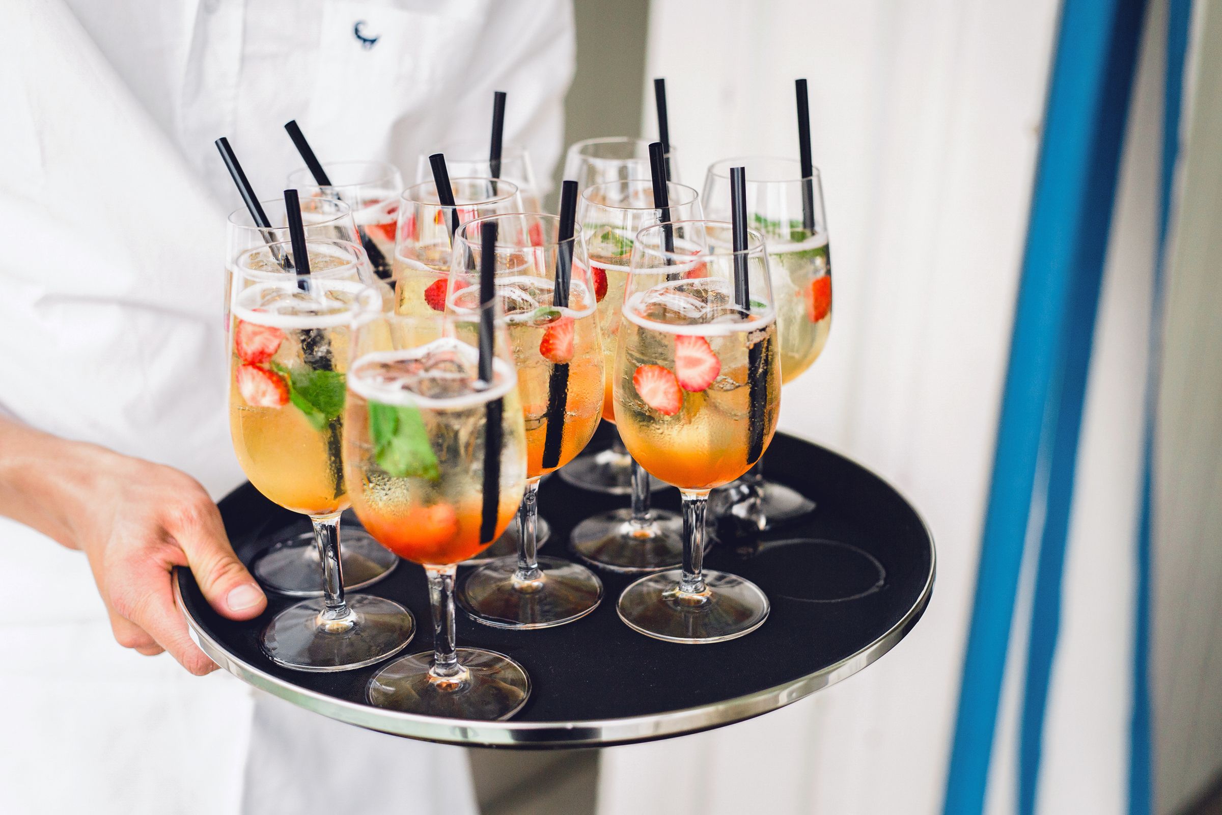 Close up of waiter serving orange festive cocktails