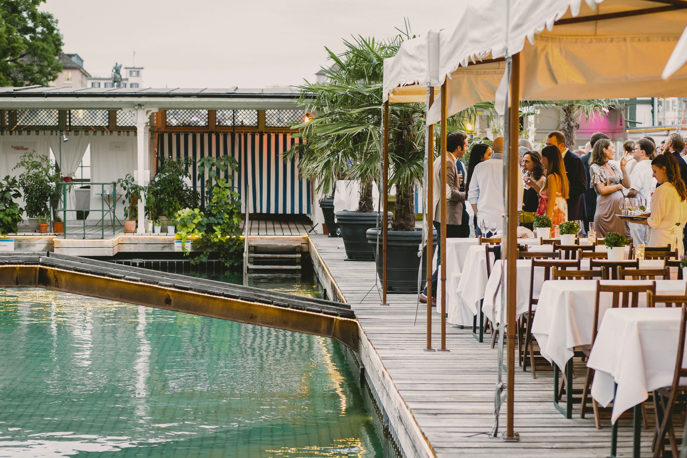 A charming wedding reception taking place next to a swimming pool, featuring beautiful decor and guests enjoying the festive atmosphere.