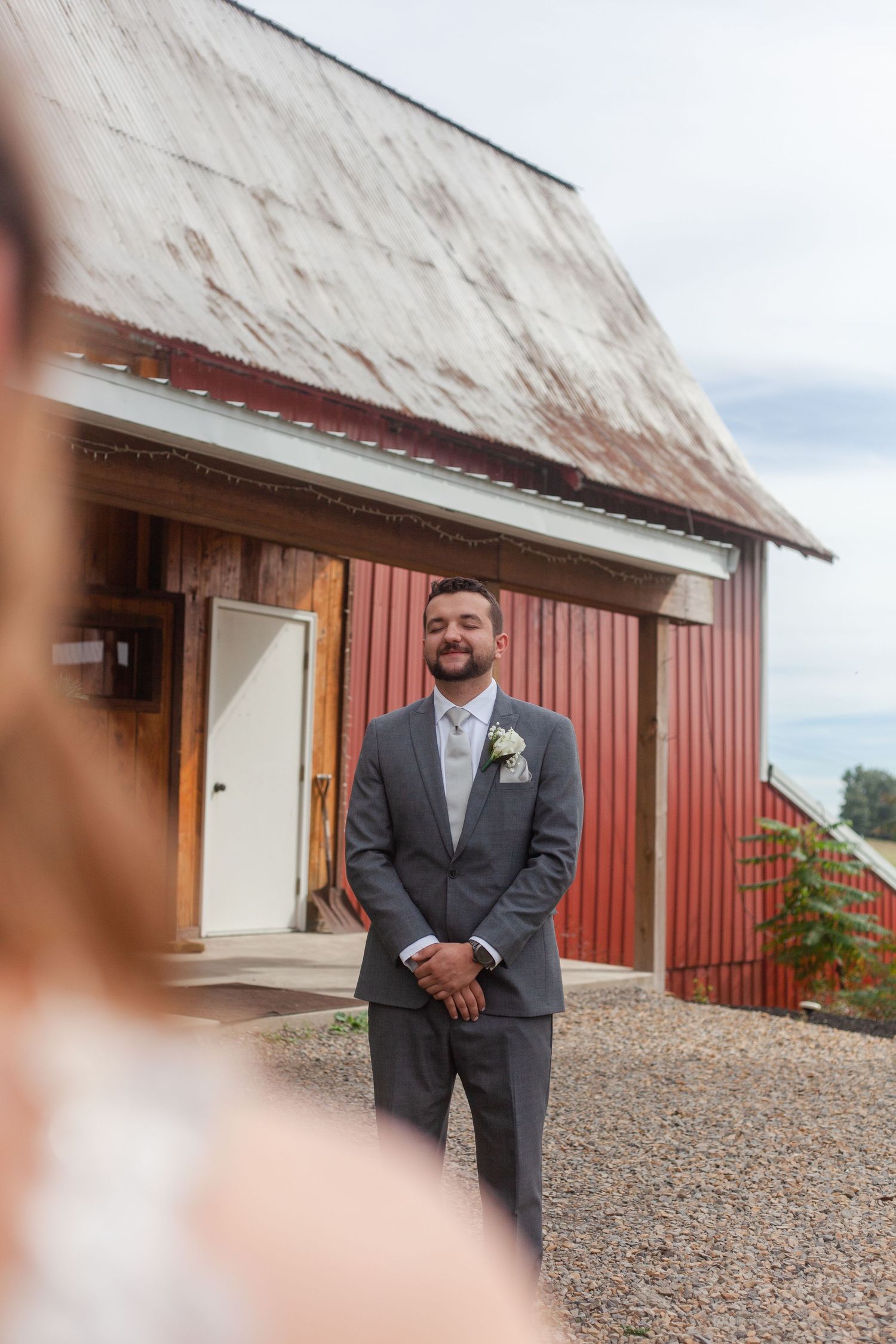 Formal portraits taken outside a rustic red barn with white trim.