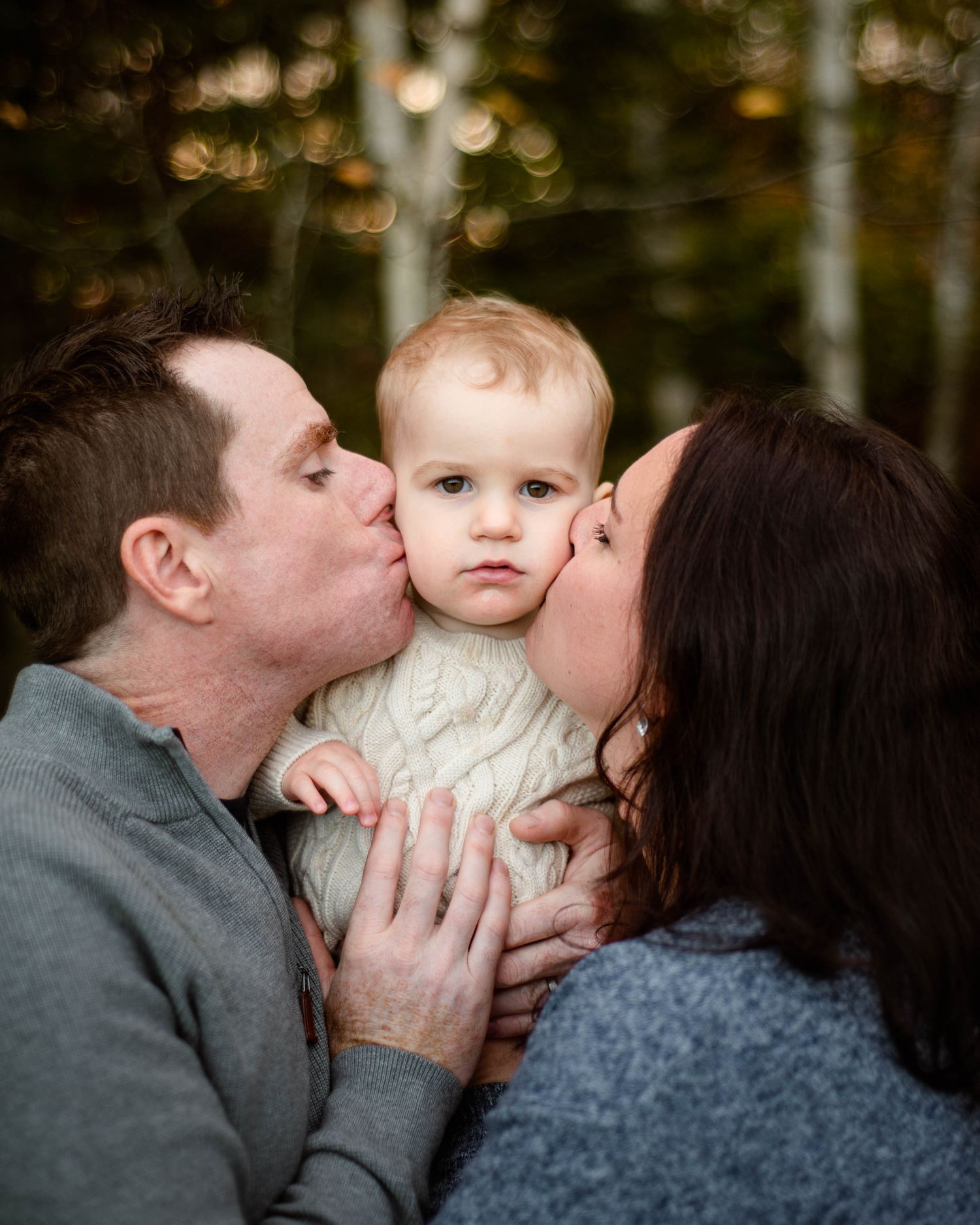 A mom and dad kiss their son's face in a family photo session in Dartmouth, Nova Scotia