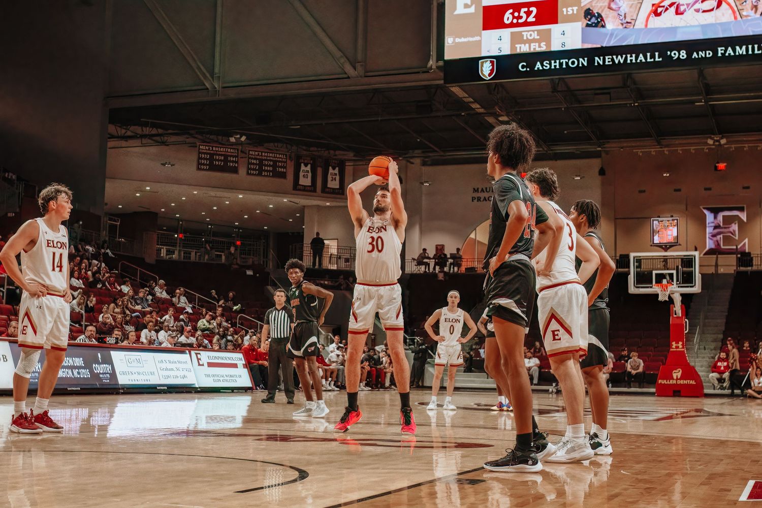 Basketball players compete for the ball during an indoor game.