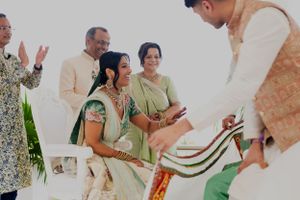 Wedding ceremony participants gather around a decorative white and red cloth.