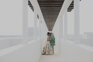 A couple stands in a modern white hallway with dramatic architectural lines.