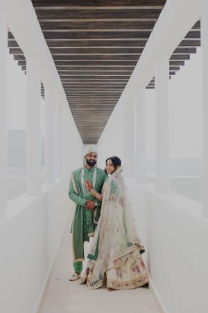 A couple sharing an intimate moment in a minimalist white corridor with wooden ceiling.