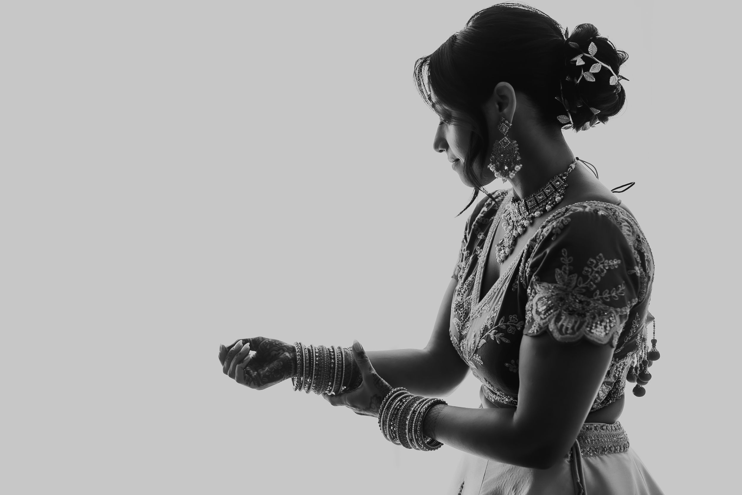 Black and white silhouette of a bride in traditional Indian attire showing jewelry details.