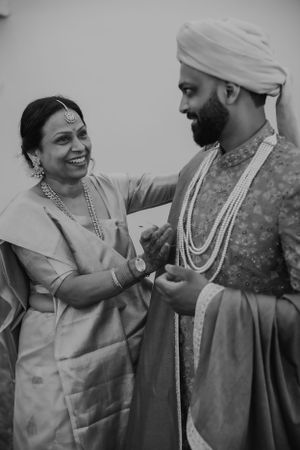 Black and white capture of heartwarming moment in traditional Indian wedding attire.