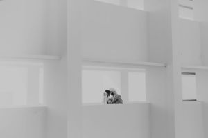 Intimate couple portraits captured in a minimalist white architectural space.