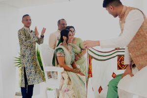 A traditional ceremony showing guests presenting a decorated cloth during wedding rituals.