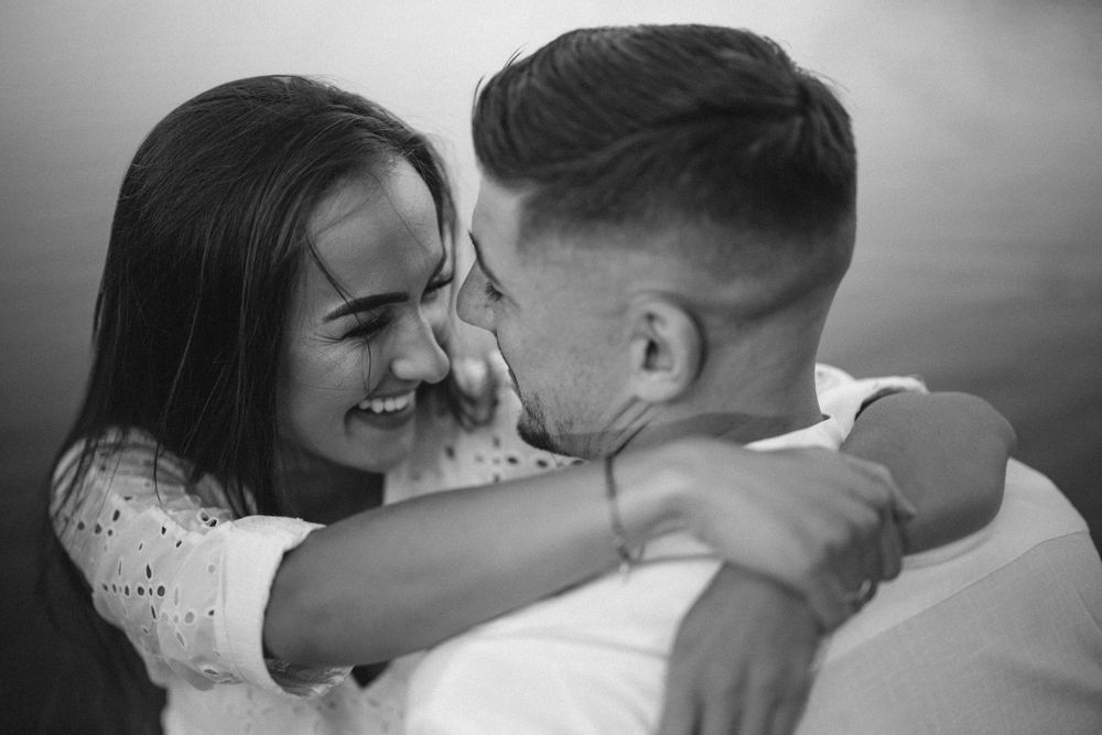 Intimate black and white portrait of a romantic couple embracing.