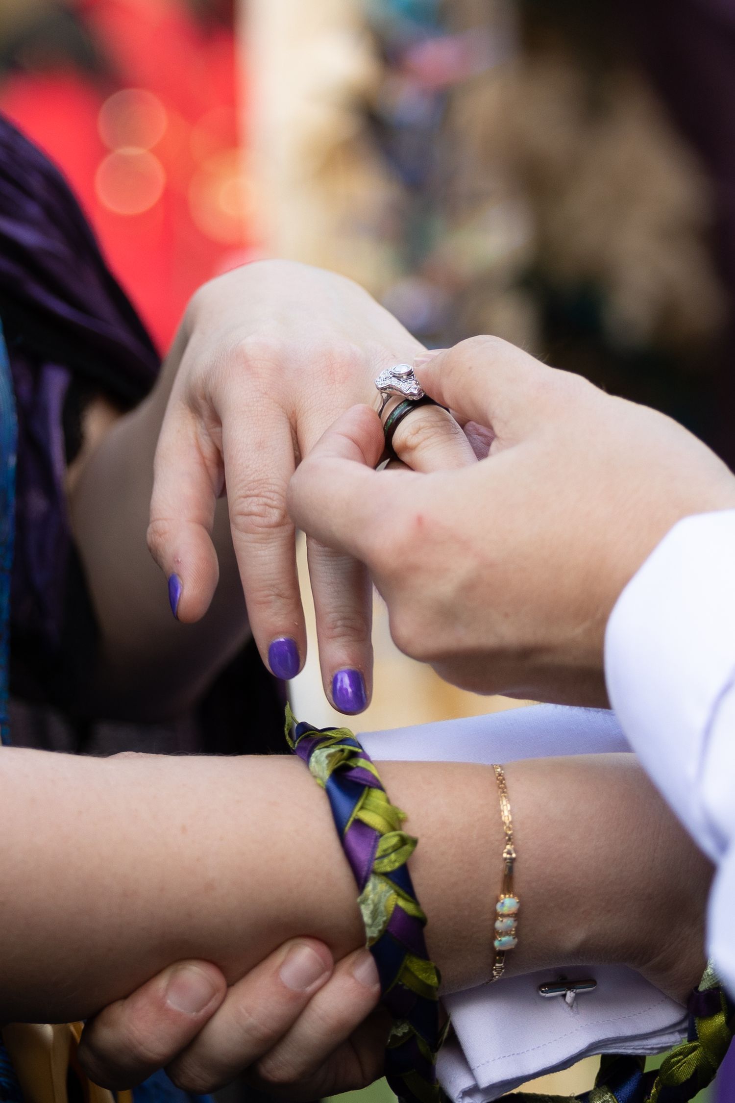Groom putting ring on bride.