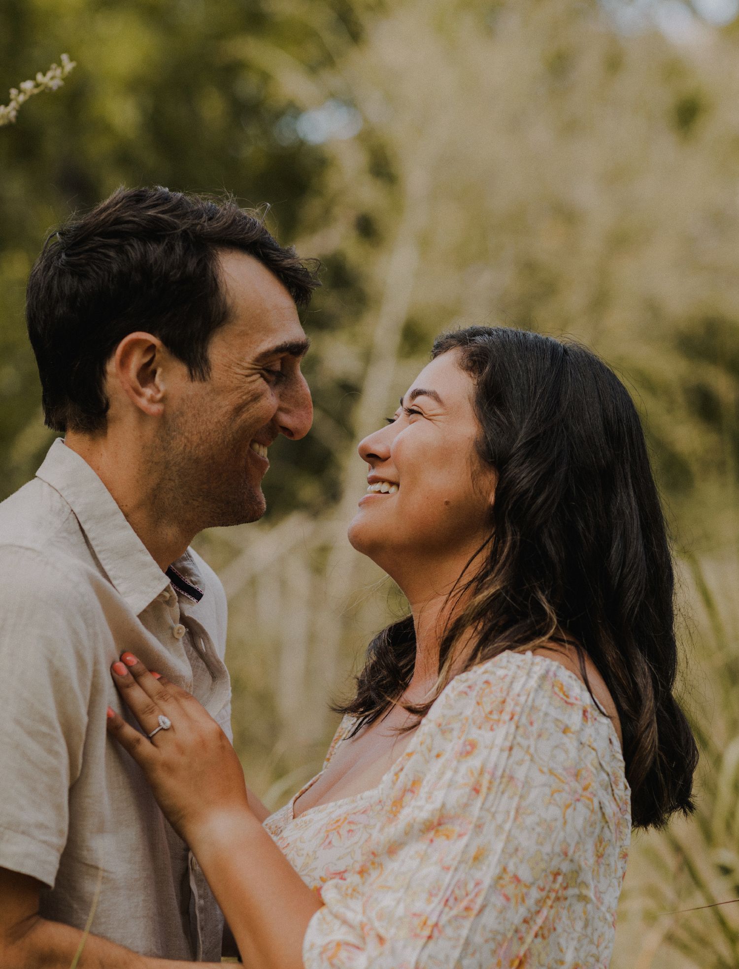 couple laughs candidly while each kissing each other on the cheek