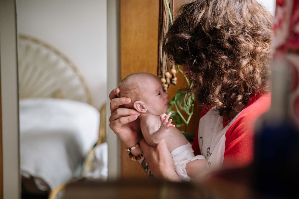 A tender moment between a parent and infant showcasing nurturing care and affection.