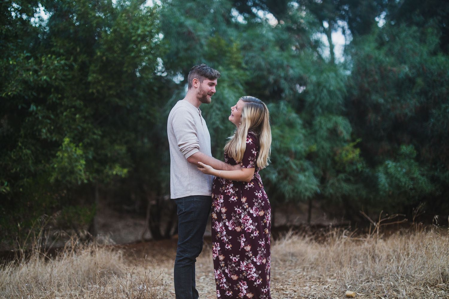 A romantic moment captured in nature with a couple in coordinated casual outfits.