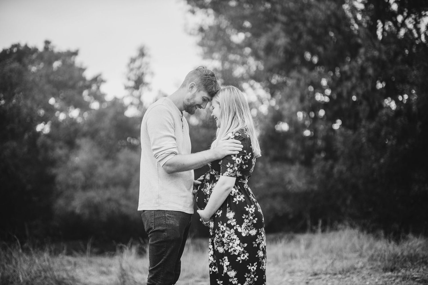 Intimate black and white portrait of couple embracing in nature.