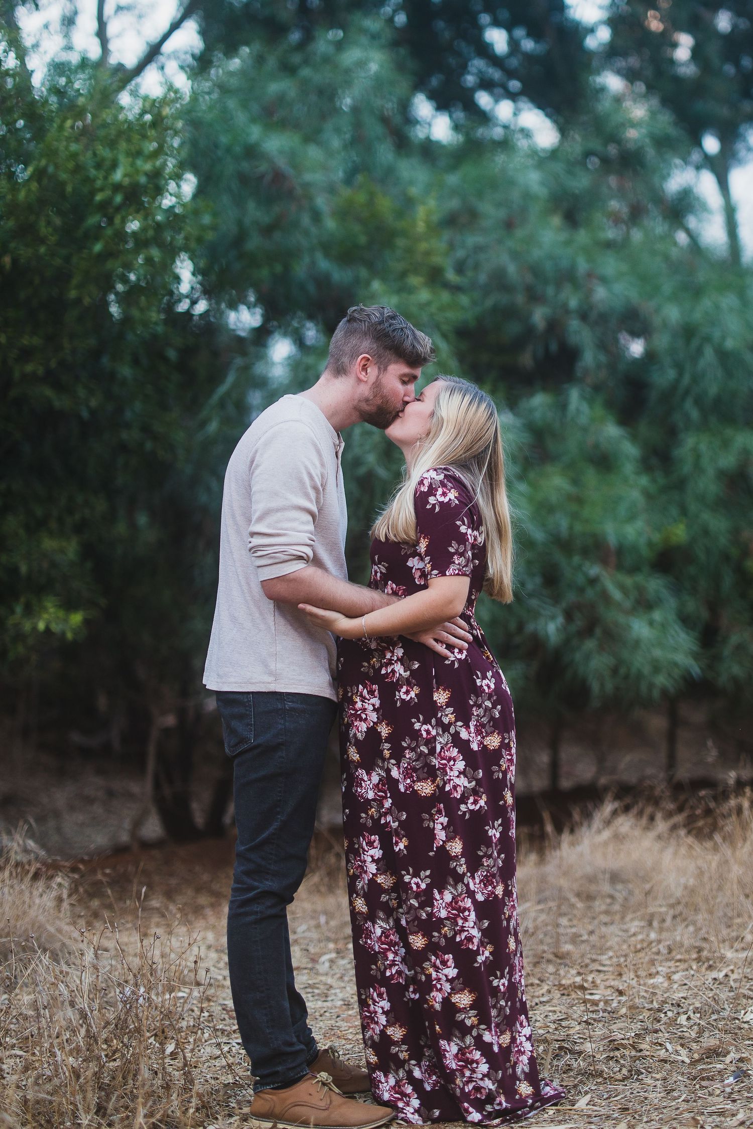 A romantic moment captured between two people in a natural outdoor setting.