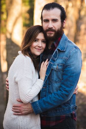 Romantic outdoor portrait of a couple embracing in casual winter clothing.